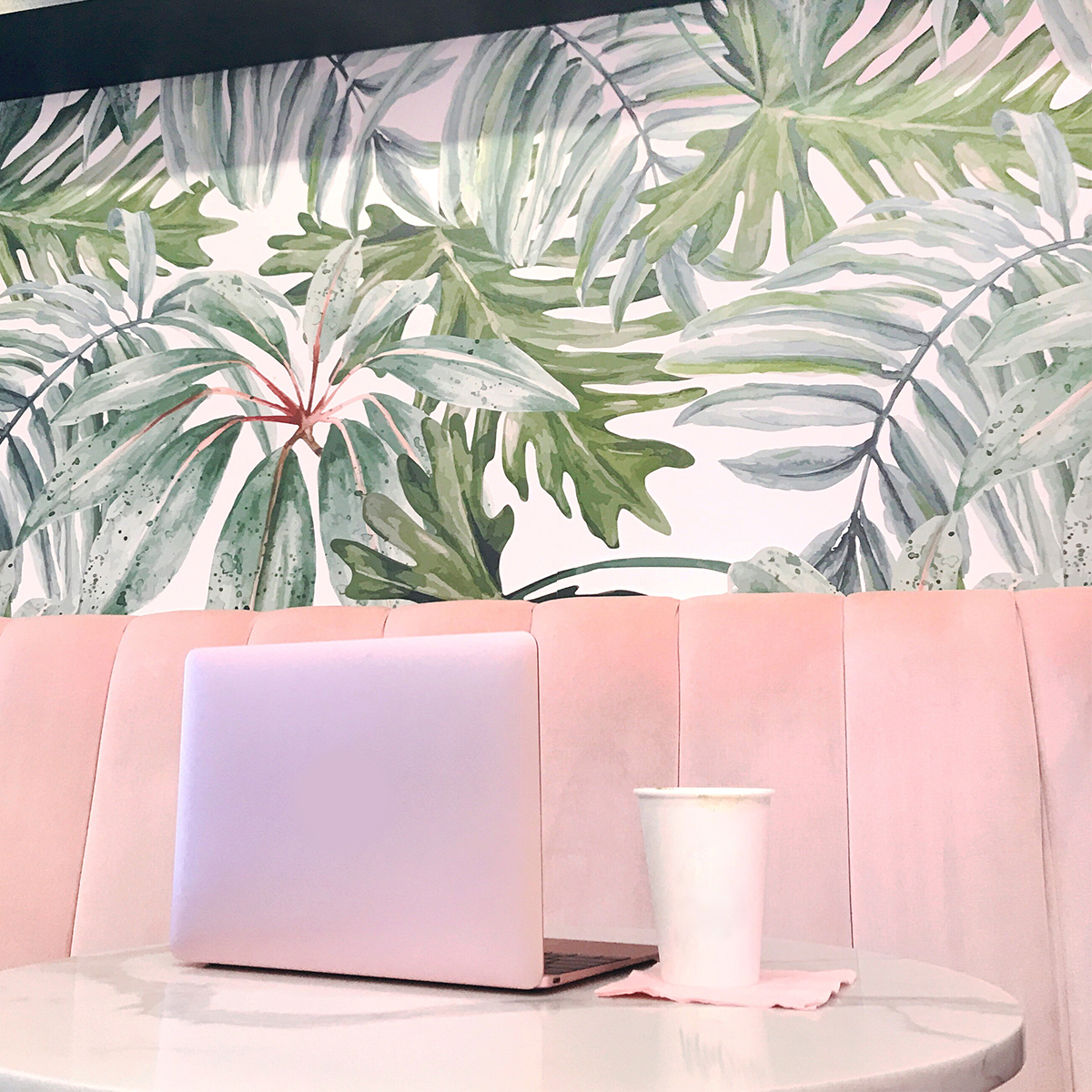 luxury wedding planner office - pink MacBook, coffee, tropical wallpaper