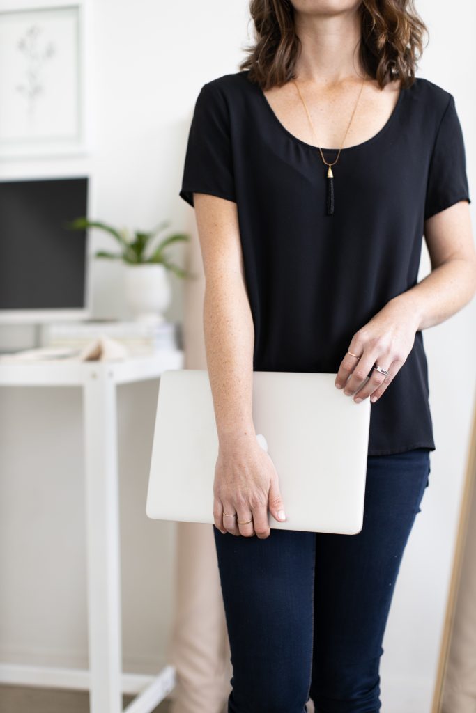 woman holding laptop - should you outsource your wedding blog