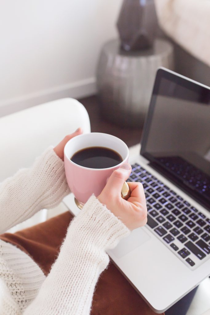 Blogging with Coffee Cup in Lap