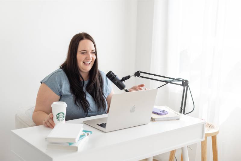 Kara Duncan sits at laptop and records episode about how to repurpose podcast episodes into evergreen blog content.